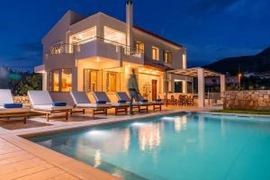 a villa with a swimming pool in front of a house at Magnolia Mansion in Kalamata