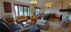 a living room with a couch and a table at Villa Maëlla- Gîtes en Normandie, tout confort, SPA et Piscine in Saint-Michel-la-Forêt