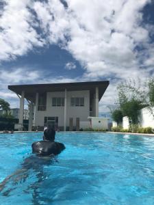 a man in a swimming pool in front of a building at Condo unit in Novaliches Quezon City near Caloocan City in Manila