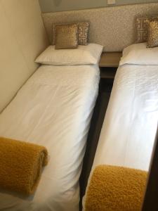 two beds sitting next to each other in a room at Seabreeze, Utopia, walking distance to beach, 5 Star Shorefield Country Park, Milford on Sea, Shorefield Road, SO41 0LH, United Kingdom in Milford on Sea