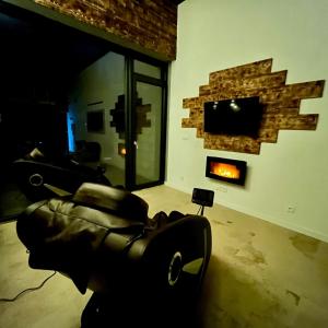 a living room with a couch and a fireplace at Appart Massage Relax - Studio in Morbier