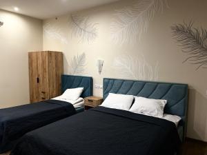 a bedroom with two beds and a wall with plants at Міні-готель Тремпель in Kharkiv