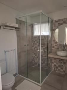 a bathroom with a shower with a toilet and a sink at Pontal Flats in Paraty +14 photos