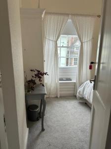 a bedroom with a window and a table and a bed at Single Room in Georgian Masionette in Blandford Forum +2 photos