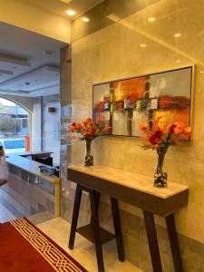 two vases with flowers on a table in a room at امواج الشرق للشقق المخدومه in Khamis Mushayt