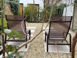 two chairs sitting next to each other in a garden at Oscarsleeps in Ghent