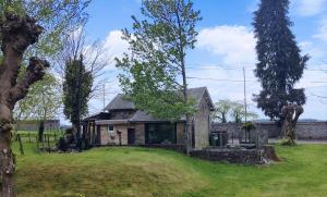an old stone house in a grassy field at Holliday Home La Douane in Gedinne