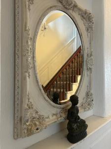 a mirror on a mantle with a statue in front of it at Single Room in Georgian Masionette in Blandford Forum