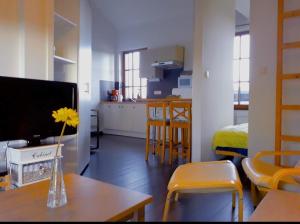 a living room with a table with a vase with a yellow flower at Holliday Home La Douane in Gedinne