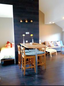 a dining room with a table and chairs and a couch at Holliday Home La Douane in Gedinne