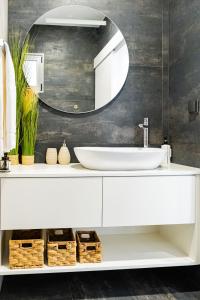 a bathroom with a white sink and a mirror at Casa da Lombada in Ponta do Sol