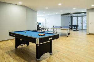 a pool table in a room with two tables at Casa da Lombada in Ponta do Sol