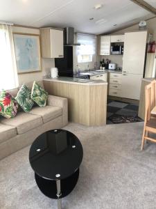 a kitchen and living room with a couch and a table at Seabreeze, Utopia, walking distance to beach, 5 Star Shorefield Country Park, Milford on Sea, Shorefield Road, SO41 0LH, United Kingdom in Milford on Sea