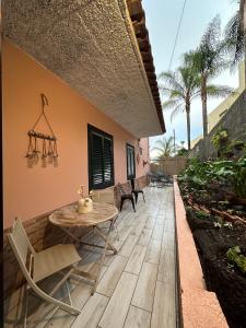 Un patio con una mesa y sillas al lado de un edificio. en Loft in Calheta Madeira, en Calheta