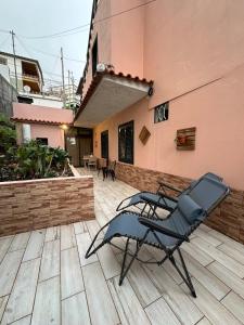 Una silla sentada en un patio al lado de un edificio. en Loft in Calheta Madeira, en Calheta