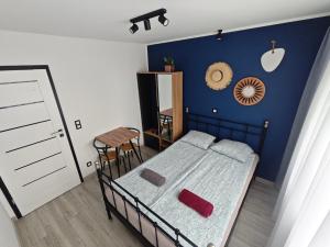 a bedroom with a bed and a blue wall at Kraken Apart in Kołobrzeg