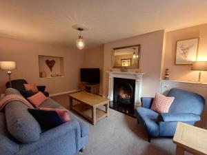 a living room with two blue chairs and a fireplace at Creel Cottage Seatown Cullen with Garden in Cullen
