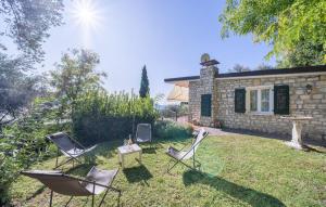 a yard with chairs and a table and a house at Casa Ileana in Gargnano