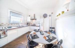 a white kitchen with a table and chairs at Casa Ileana in Gargnano