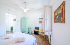 a white bedroom with a bed and a desk at Casa Ileana in Gargnano