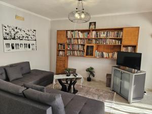 a living room with a couch and a tv at Library Apartment by Bohem Rentals in Durrës