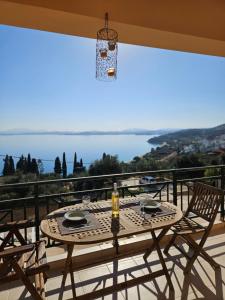 a table on a balcony with a view of the water at Ionelia Seaview Apartment at Barbati in Barbati