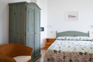 a bedroom with a bed and a cabinet and a chair at Residence Chiesiola in Vieste