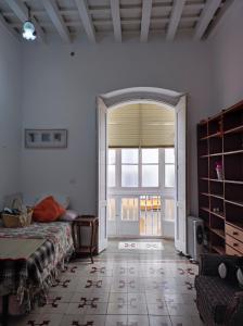 une chambre avec un lit et une grande fenêtre dans l'établissement Old Merchant's Home, à Cadix
