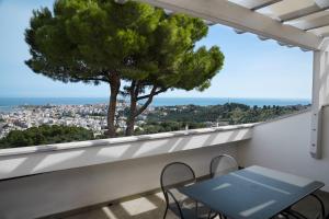 a table and chairs on a balcony with a tree at Residence Chiesiola in Vieste