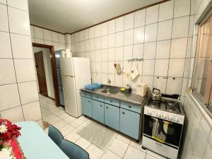 Una pequeña cocina con estufa y refrigerador. en Apartamento - Pé na Areia, en Itapema