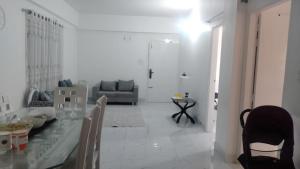 a white living room with a table and a couch at Airport Bliss Residence in Chandālbhog