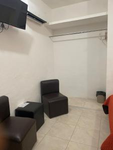 - un salon avec deux chaises et une télévision à écran plat dans l'établissement La Quinta Perez, à Huay Pix