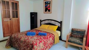 a bedroom with a bed with two blue pillows on it at Viajeros Centro in Machu Picchu
