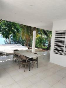 une table et des chaises assises sous un parasol blanc dans l'établissement La Quinta Perez, à Huay Pix