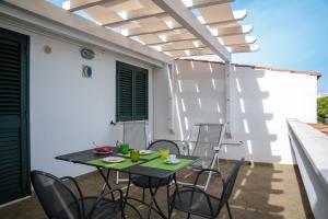 a patio with a table and chairs under a pergola at Residence Chiesiola in Vieste