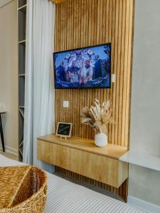 Cette chambre dispose d'une télévision sur un mur en bois. dans l'établissement Hygge VIP Haven by NEXT WHITE, à Batoumi