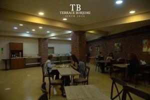 a group of people sitting at tables in a restaurant at Terrace Borjomi Hotel in Borjomi