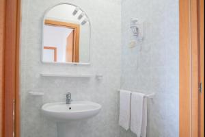 a white bathroom with a sink and a mirror at Residence Chiesiola in Vieste
