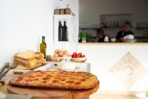 a pizza sitting on a cutting board in a kitchen at Residence Chiesiola in Vieste