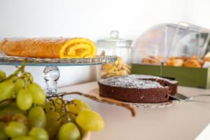 a plate with a cake and some grapes on a counter at Residence Chiesiola in Vieste