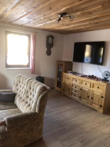 un salon avec un canapé et une télévision à écran plat dans l'établissement Chata pri potoku, à Hruštín