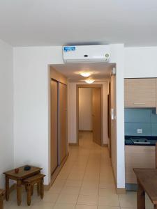 a hallway of a room with a kitchen and a table at Suíte Deluxe Soares in Prainha