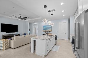 cocina y sala de estar con sofá y TV en Sunrise Island Retreat, en Fort Pierce