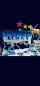 ein Schild mit einem Hund und Sternen auf einem Bett in der Unterkunft Maison atypique avec un grand terrain !animaux bienvenus !wifi netflix écran plat 4k in Les Forges