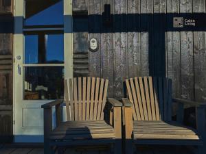 two wooden chairs sitting in front of a door at Cozy mountain cabin with sauna, fireplace & bbq in Flå