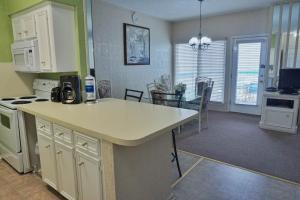 a kitchen with a counter top and a dining room at Four Seasons on the Gulf in Galveston