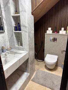 a bathroom with a white toilet and a sink at Duplex Sur Marrakech Guéliz in Marrakesh +8 photos
