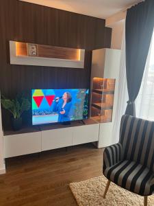 a living room with a television and a chair at Delta SPA Residence in Niš