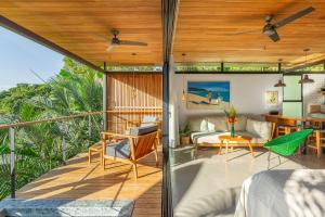 a room with a balcony with a bed and a table at The Green House, Santa Teresa - Adults Only in Santa Teresa Beach