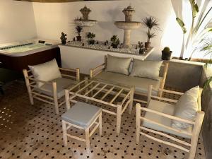 a room with chairs and a bench and a bath tub at Duplex Sur Marrakech Guéliz in Marrakesh